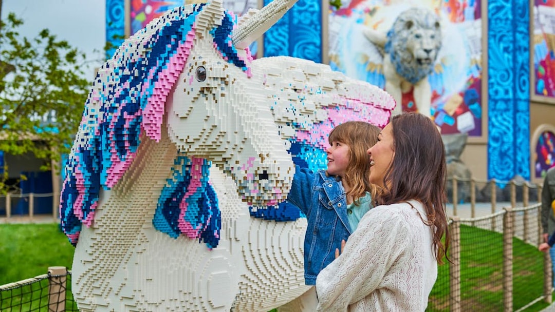 Child and adult admiring LEGO unicorn at LEGOLAND® Windsor Resort.