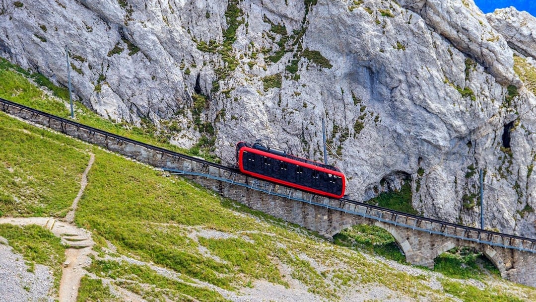 Red cogwheel train ascending Mount Pilatus near Lucerne, Switzerland.