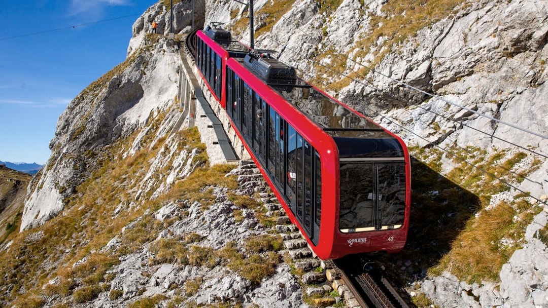 Red cogwheel train ascending Mount Pilatus near Lucerne, Switzerland.