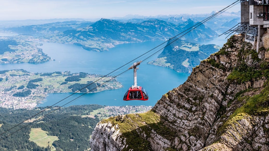 Cable car ascending Mount Pilatus with Lake Lucerne in the background.