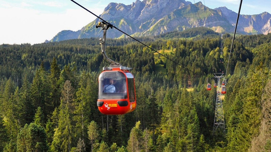 Cable car ascending Mount Pilatus with forest and mountain backdrop, Lucerne.