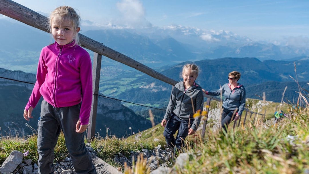 Family hiking on Mount Pilatus trail with scenic views, Lucerne.