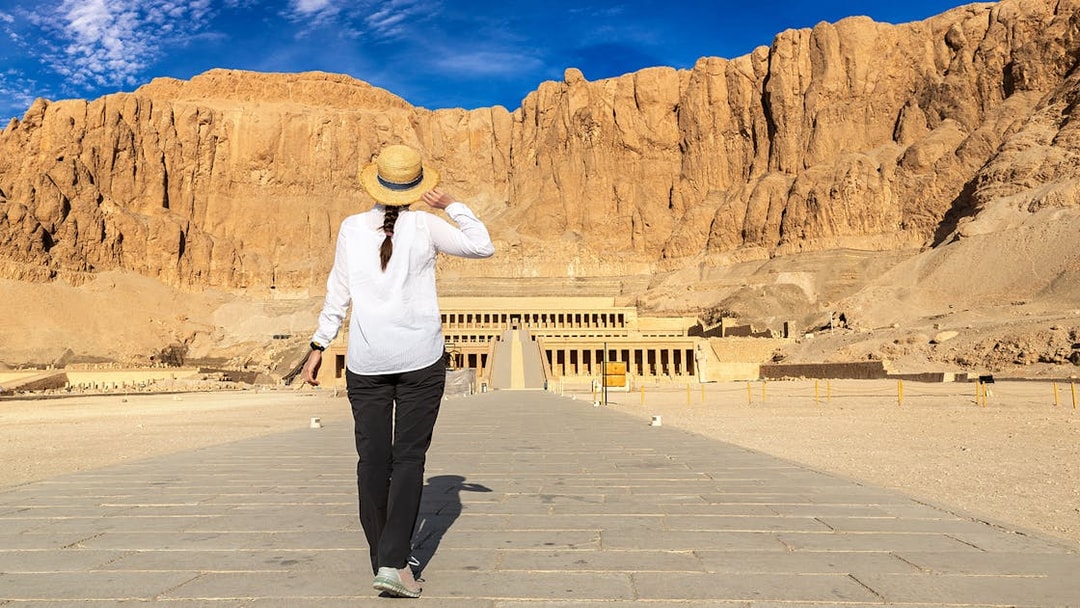 Tourist walking towards Hatshepsut Temple in Valley of the Kings, Egypt.