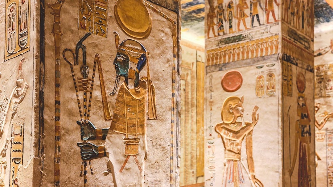 Ancient Egyptian hieroglyphs and deities on tomb walls in the Valley of the Kings, Luxor, Egypt.