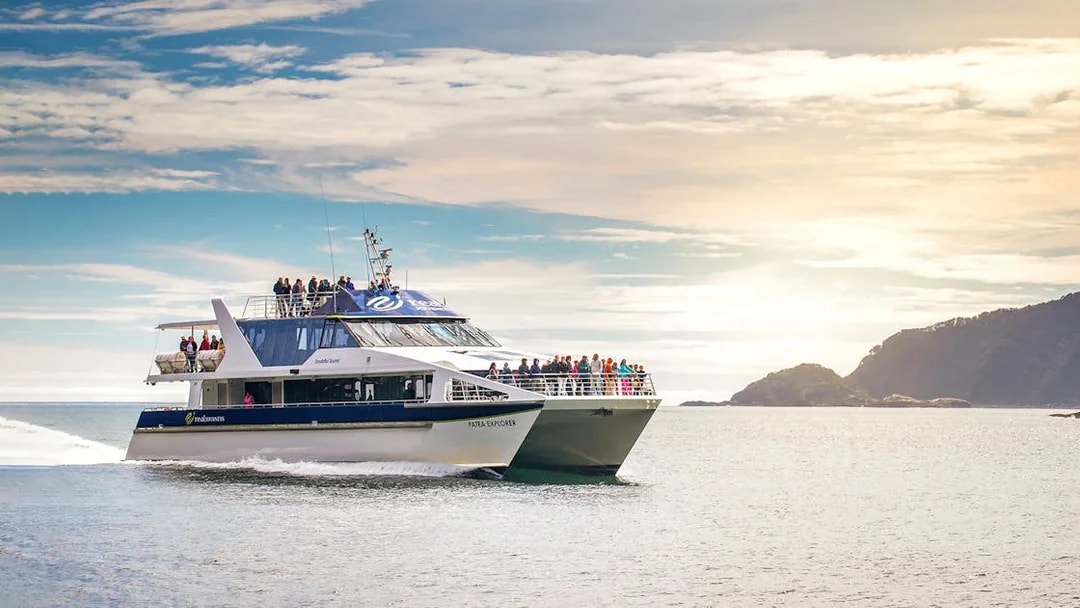 Cruise boat on Doubtful Sound with passengers enjoying scenic views, Manapouri.