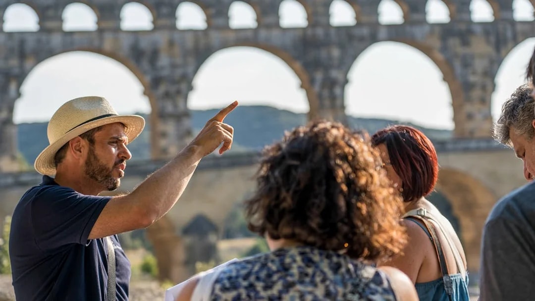 Tour guide explaining Pont du Gard to visitors in Provence.