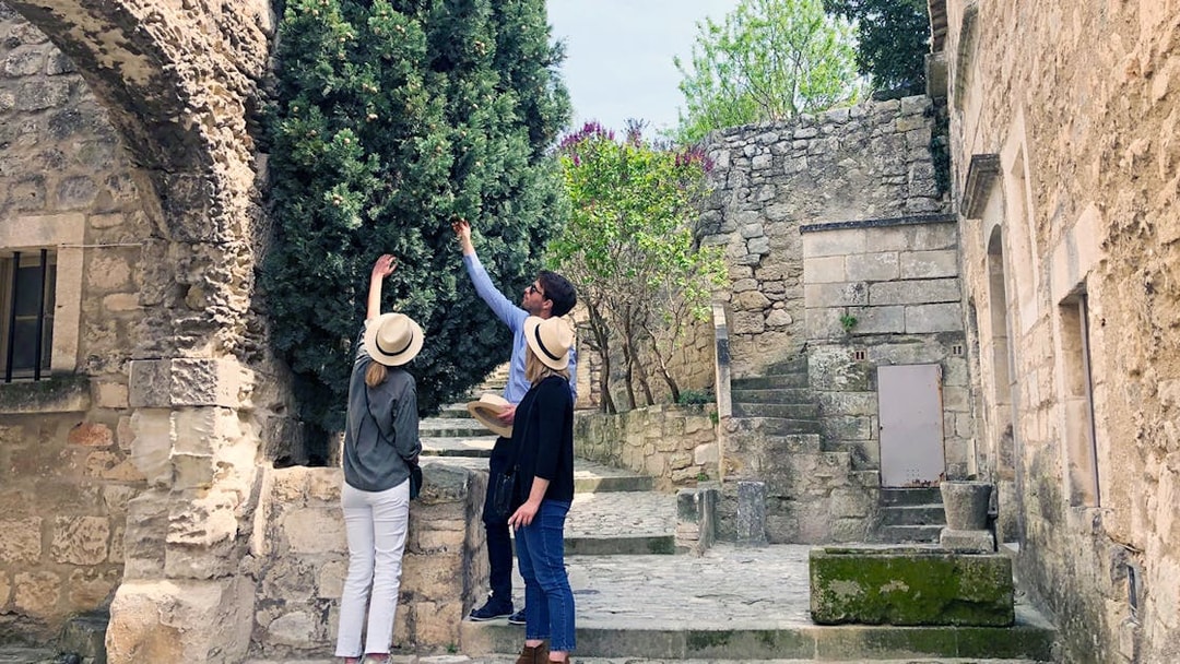 Tourists exploring historic stone architecture in Provence, France.
