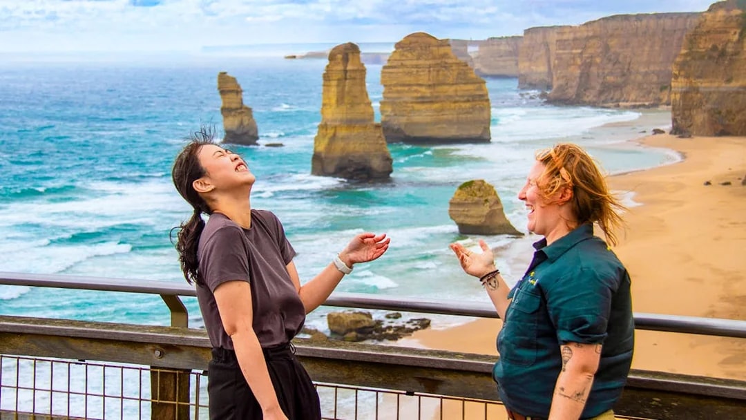 Tourists enjoying the view of the 12 Apostles on a Great Ocean Road guided tour.