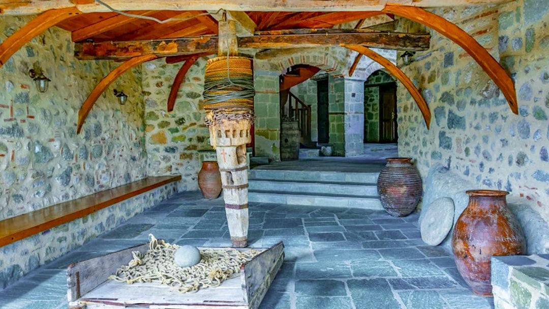 Monastery of the Holy Trinity at Meteora interior with stone walls and wooden beams.