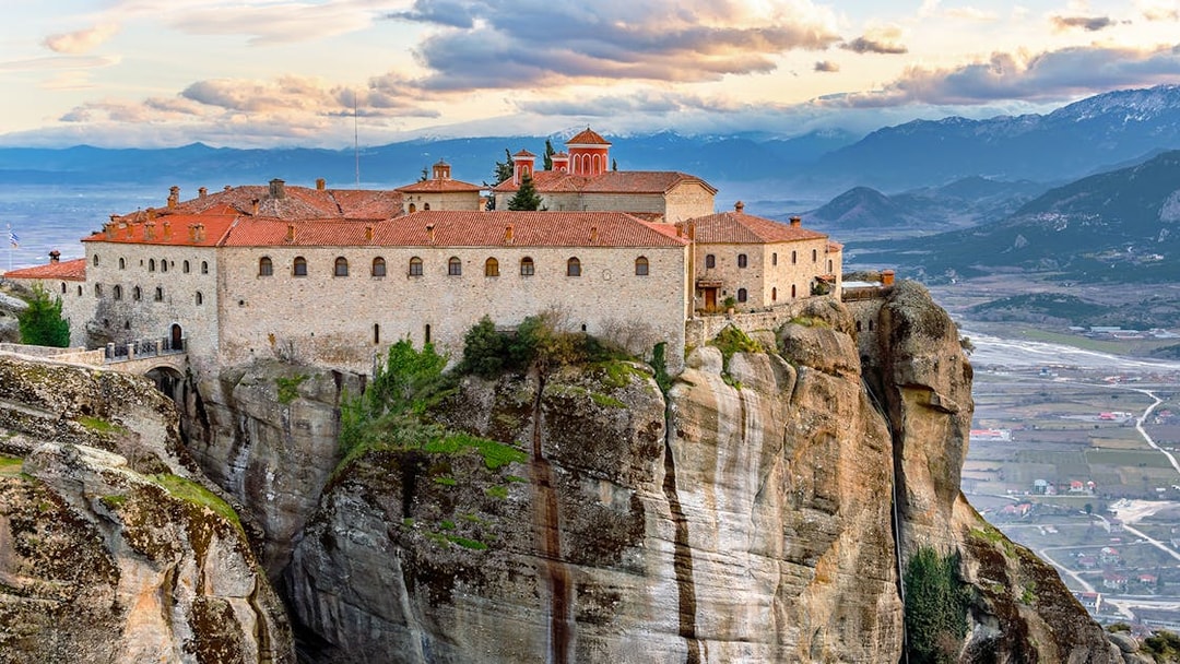 Meteora monastery perched on rock formation, view from 1-day train tour from Athens.