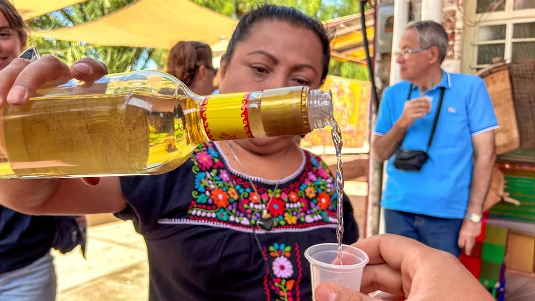 Pouring tequila into a cup during a tasting event in Mexico.