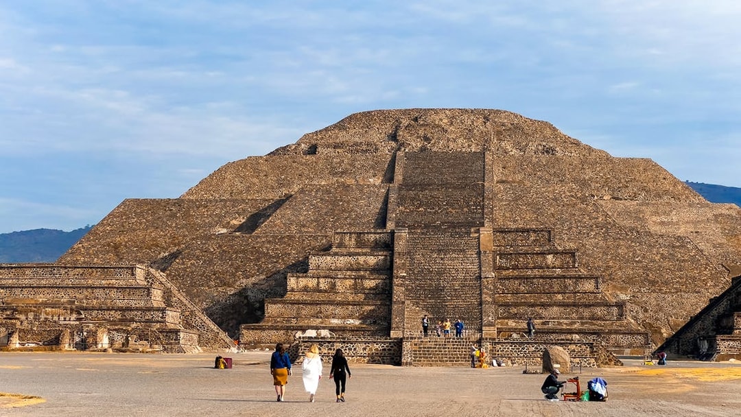 Pyramid of the Moon in Teotihuacan, Mexico, with visitors exploring the ancient site.