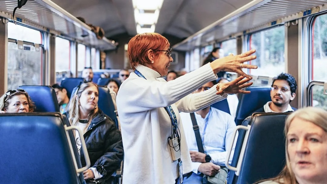 Tour guide speaking to passengers on the Bernina Red Train, St. Moritz.