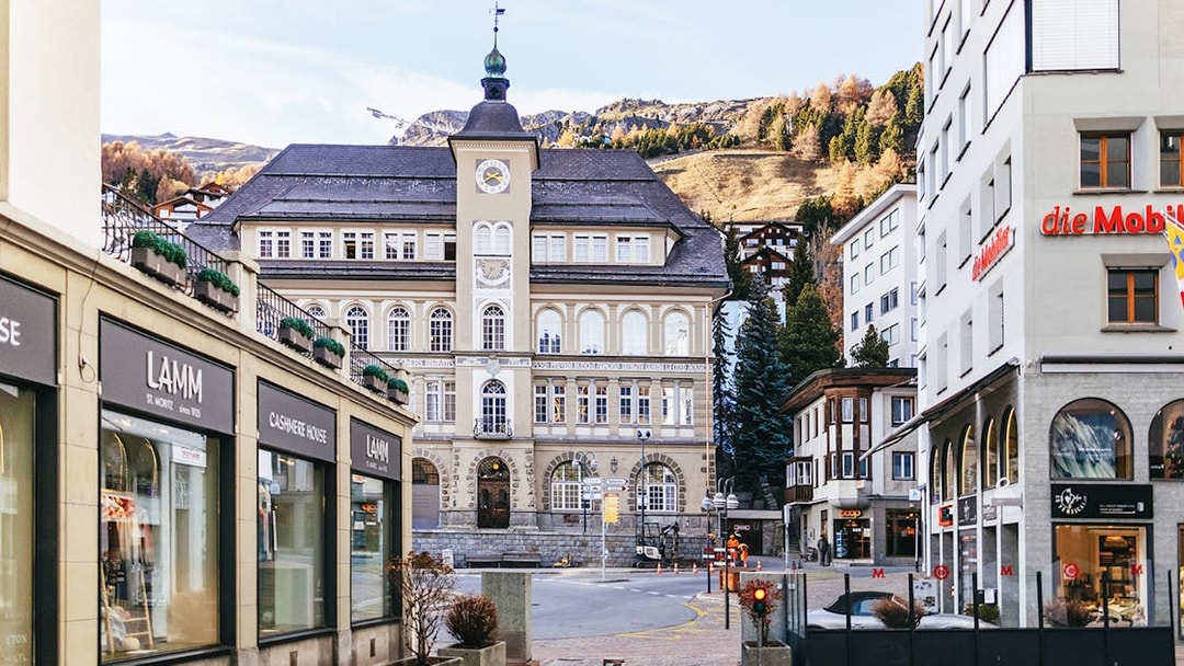 St. Moritz town center with historic building and mountain backdrop.