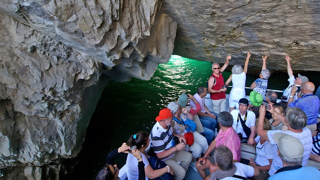 Tourists on a boat exploring a sea cave in Capri, Italy.