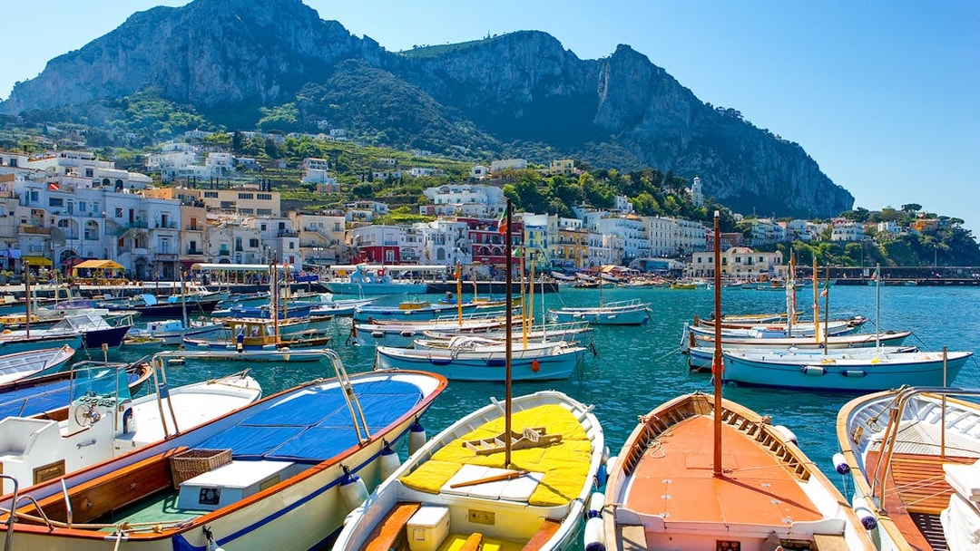 Boats docked at Marina Grande with Capri's cliffs in the background, Island of Capri.
