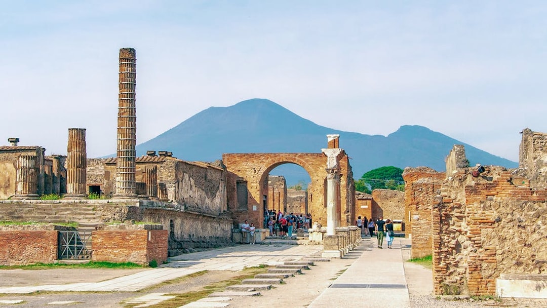 Ancient ruins of Pompeii with Mount Vesuvius in the background.