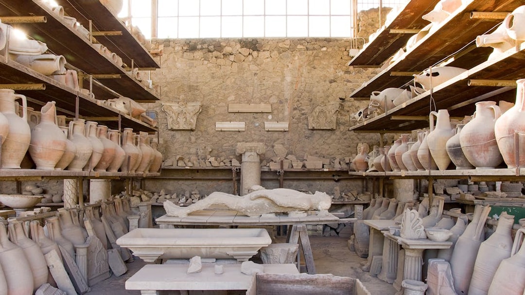 Lava cast of a person surrounded by ancient pottery in Pompeii.