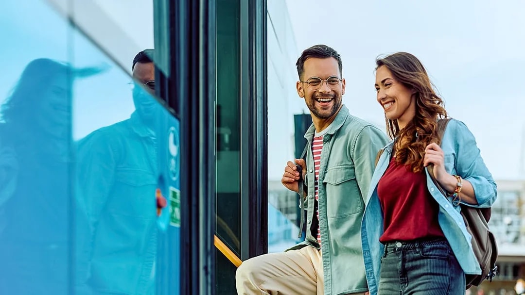 Passengers boarding a coach bus with smiles, ready for a tour.