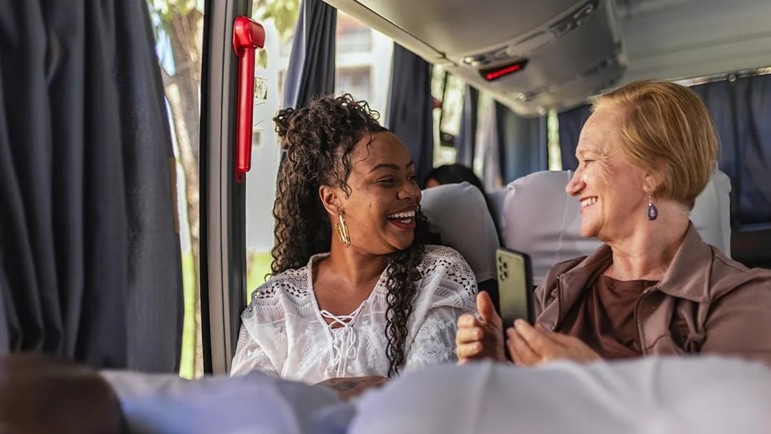 Customers smiling on air-conditioned bus during Herculaneum tour from Naples.
