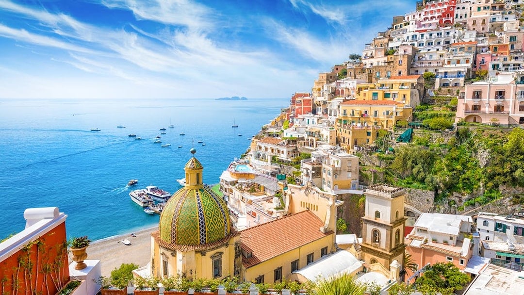 Positano coastline with colorful buildings and dome, view from Amalfi tour.