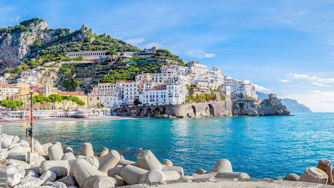 Positano coastline with colorful hillside buildings and clear blue sea, part of Amalfi tour.