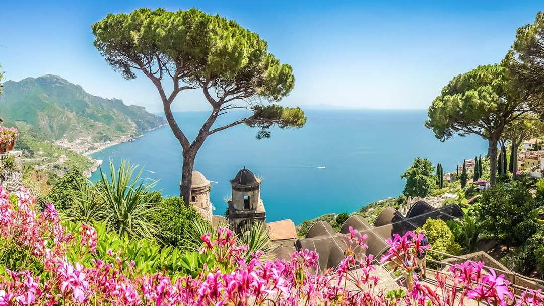 View of the Amalfi Coast from Ravello with vibrant flowers and Mediterranean Sea.