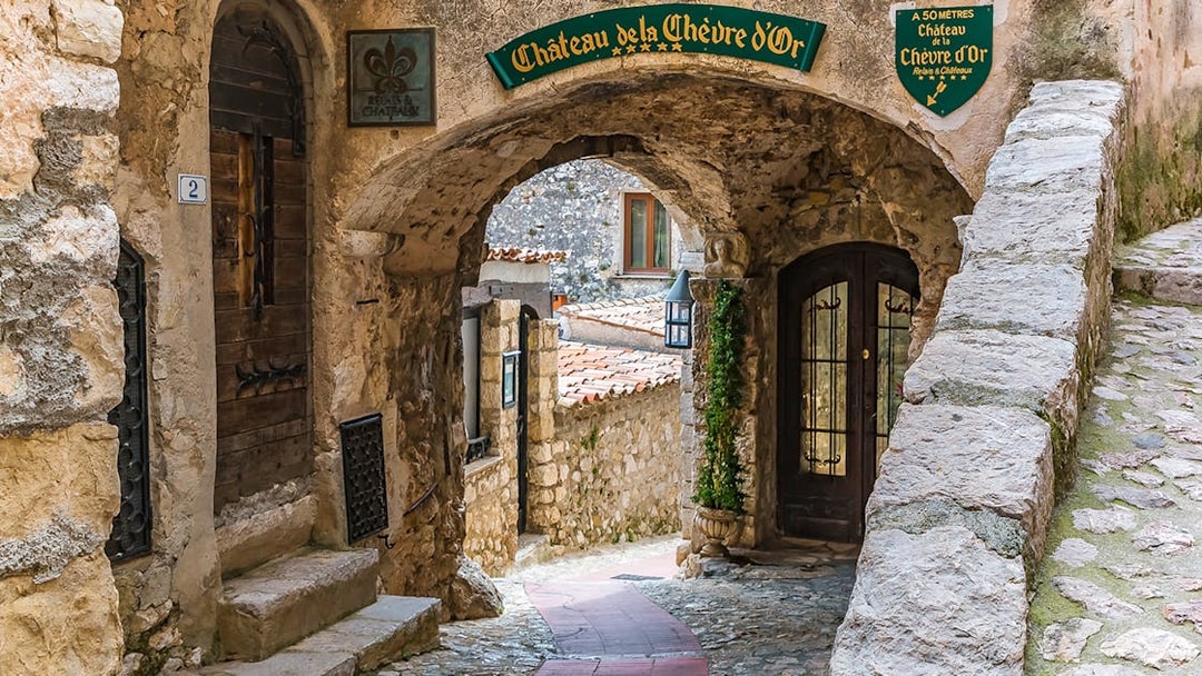 Stone archway and cobblestone path in Eze, leading to Château de la Chèvre d'Or.