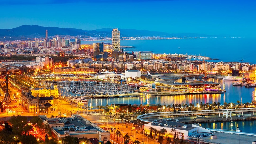 Monaco skyline at night with illuminated harbor and cityscape.