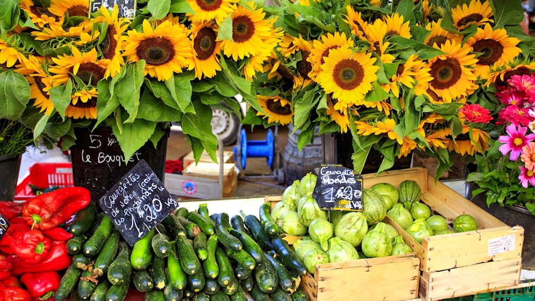 Sunflowers and fresh produce at a Provencal market stall.