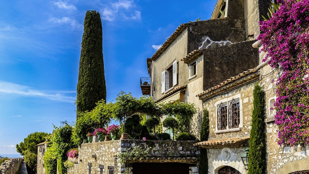 Stone house with flowers and greenery in Saint Paul de Vence, France.