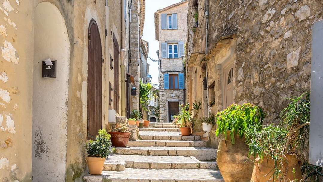 Stone alley with potted plants in Saint Paul de Vence, France.
