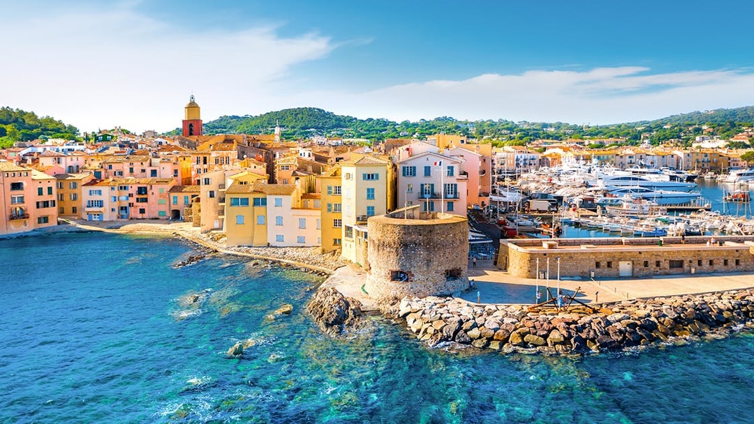Saint-Tropez harbor with colorful buildings and yachts along the waterfront.