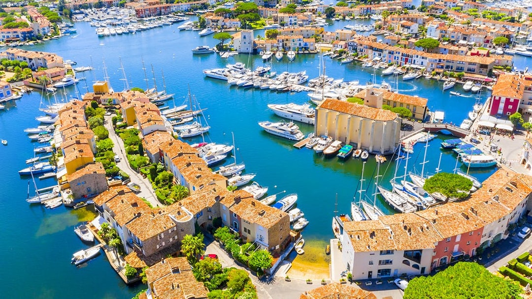 Aerial view of Port Grimaud with boats docked along canals and colorful buildings.