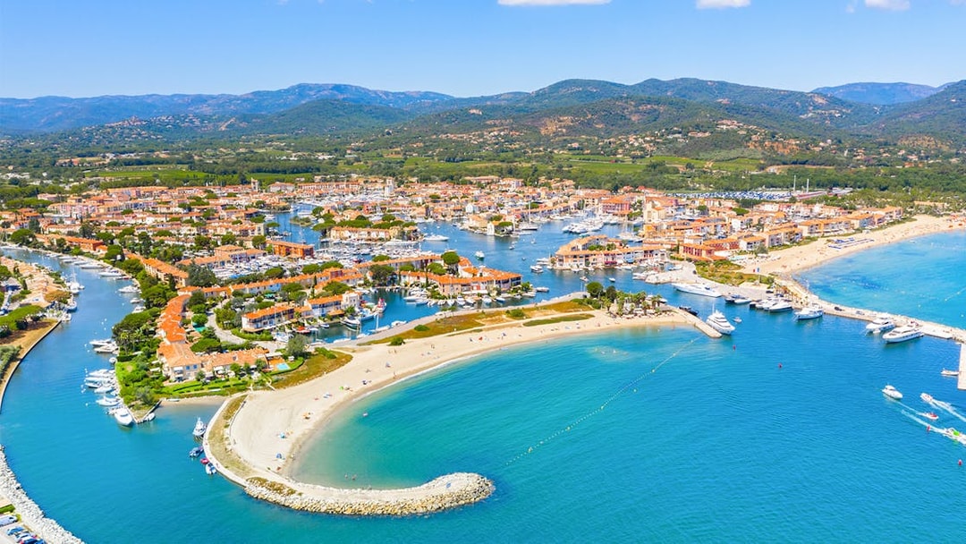 Aerial view of Port Grimaud with canals, boats, and sandy beaches on the St Tropez day tour from Nice.