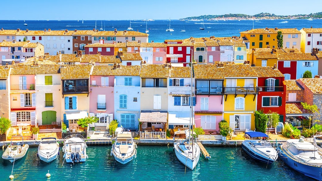 Colorful buildings and boats in Port Grimaud, France, viewed from the water.