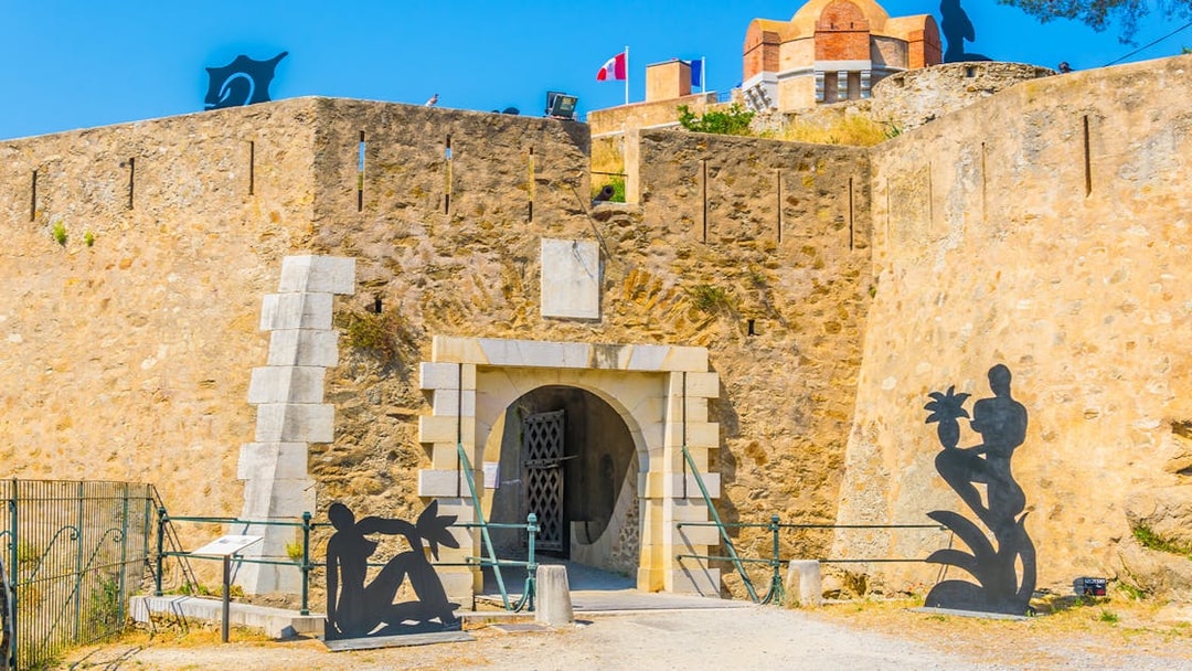 Entrance of the Citadel of Saint Tropez with sculptures and stone walls.