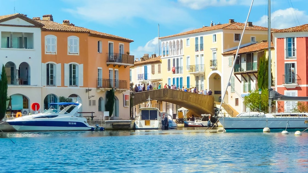 Port Grimaud canal with colorful buildings and boats, part of St Tropez day tour from Nice.