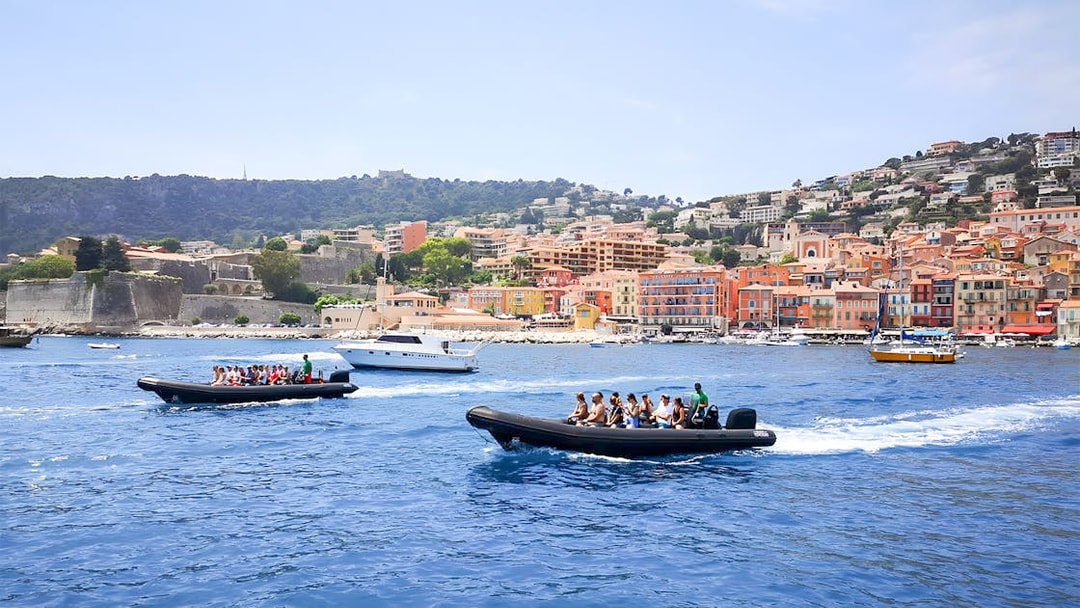 People on a boat tour near colorful buildings of St Jean Cap Ferrat.