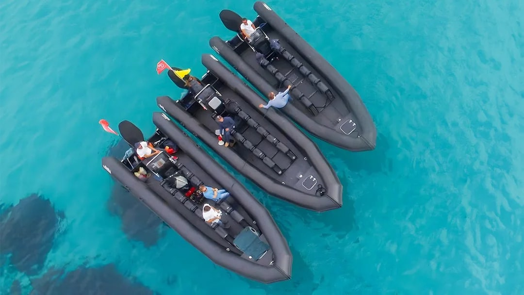 Three inflatable boats with passengers on clear blue water near St Jean Cap Ferrat.