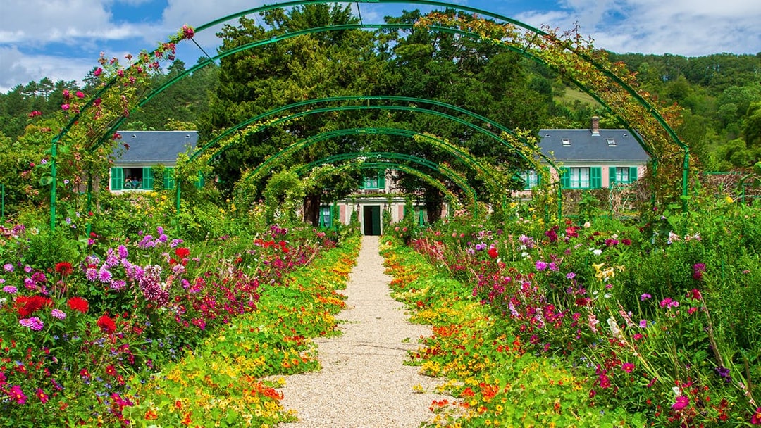 Pathway through vibrant gardens leading to Monet's House in Giverny, France.