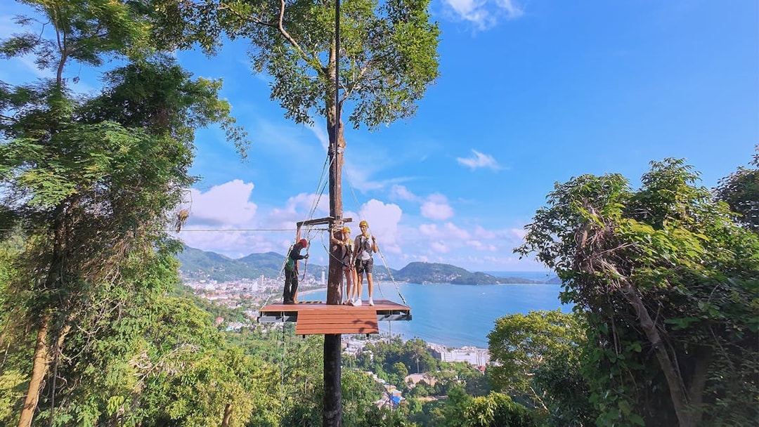 Ziplining platform with tourists overlooking Patong Bay, Phuket.
