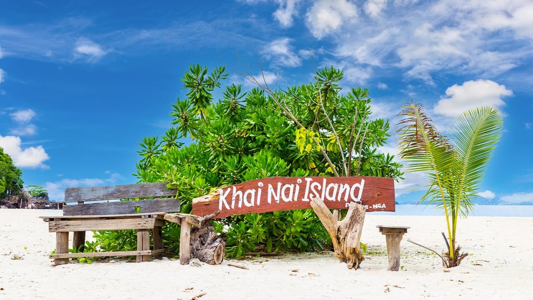Khai Nai Island sign on sandy beach with tropical plants, part of Phuket 3 Khai Island tour.