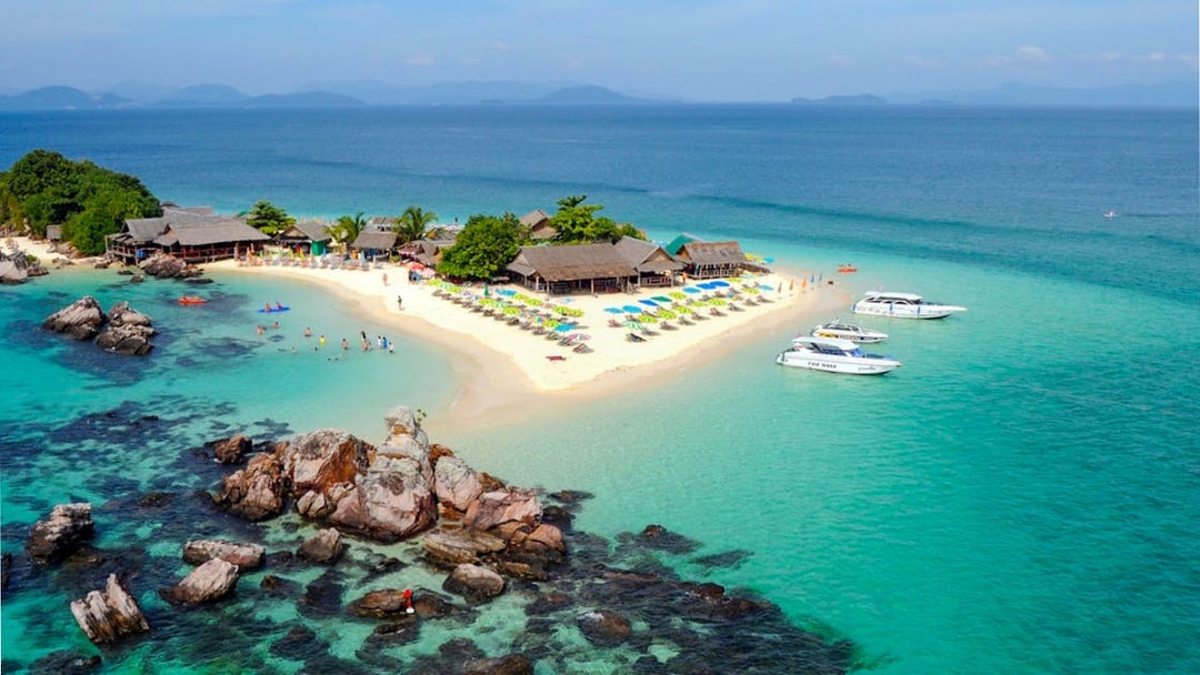 Aerial view of Khai Island beach with speedboats and tourists, part of Phuket half-day tour.