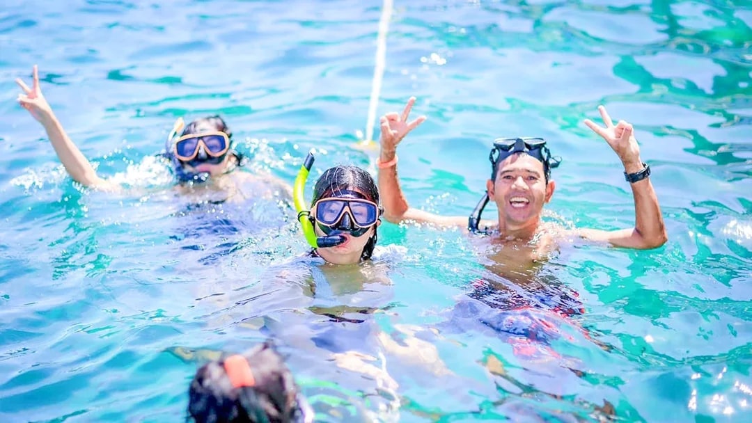 Snorkelers enjoying turquoise waters in Khai Islands.