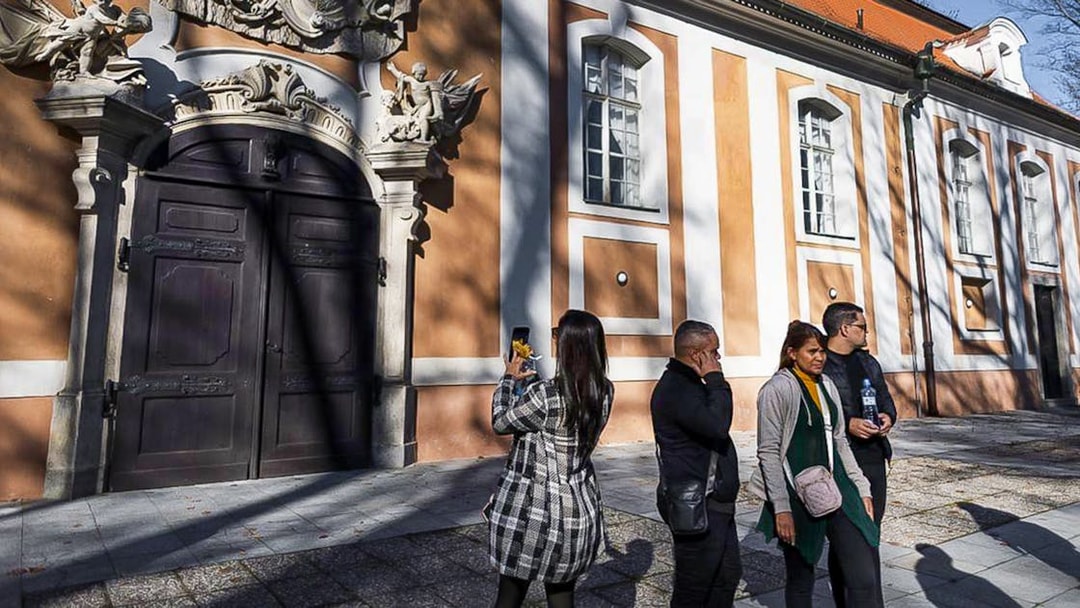 Tourists outside a historic building in Cesky Krumlov during a guided tour.
