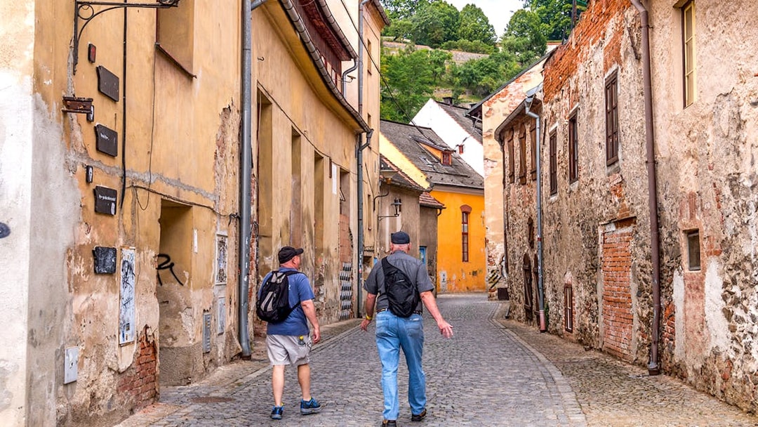 Tourists walking through a narrow cobblestone street in Cesky Krumlov.