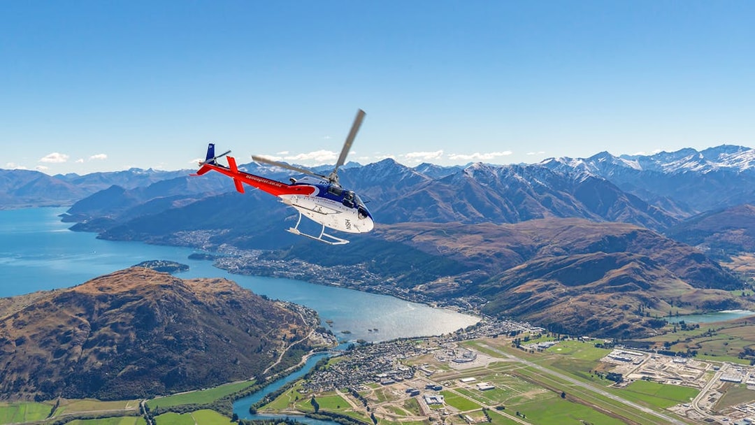 Helicopter flying over Queenstown with view of mountains and lake on Milford Sound Fly-Cruise-Heli Tour.