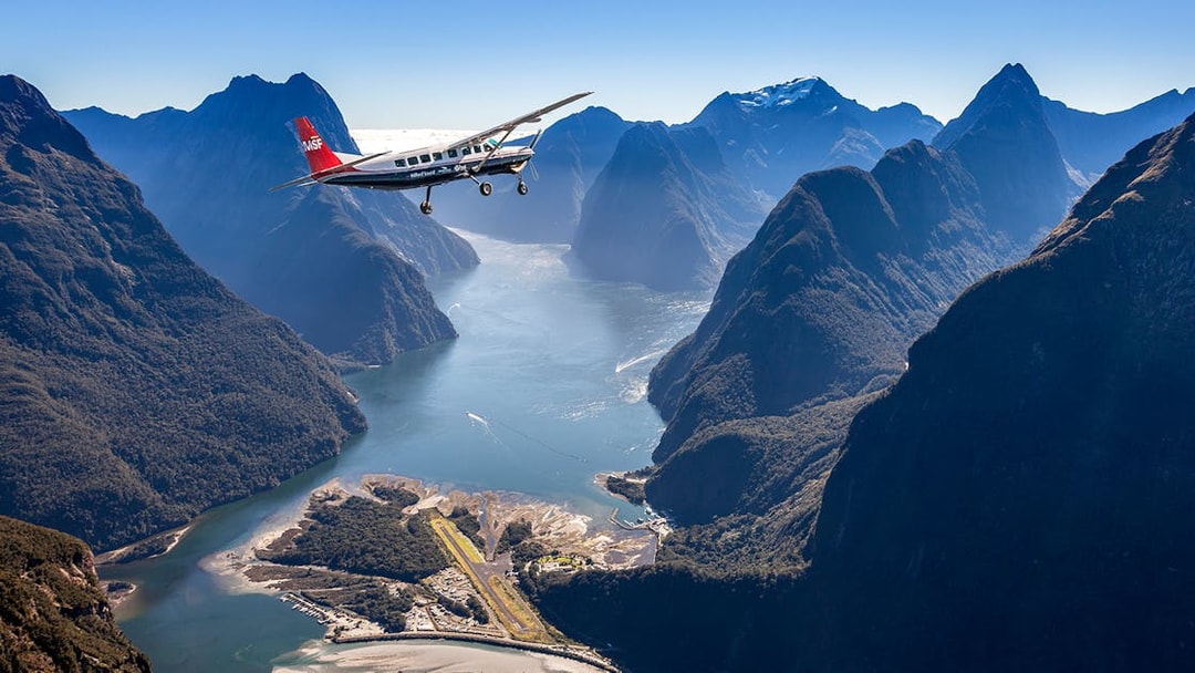 Aerial view of Milford Sound with cruise ship and plane, Queenstown flyover experience.