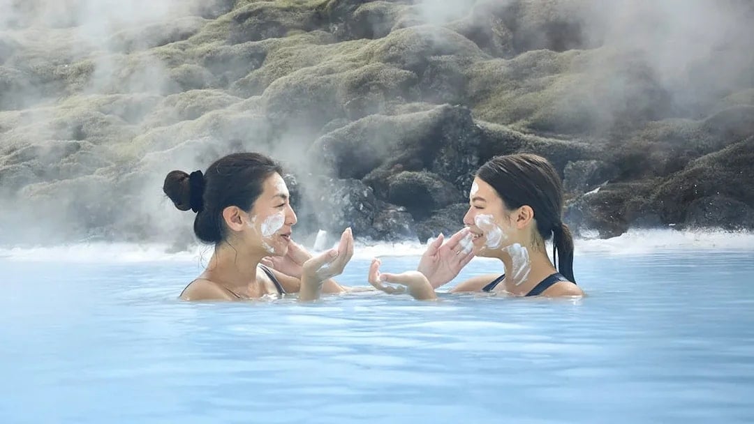 Female tourists applying face masks at Blue Lagoon, Iceland.